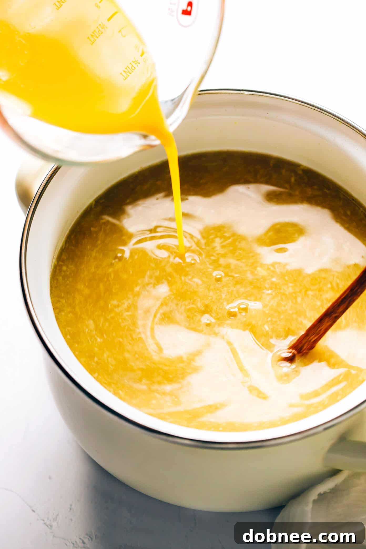 A ladle serving a bowl of homemade egg drop soup.