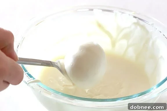 Dipping Golden Oreo Truffles in White Almond Bark