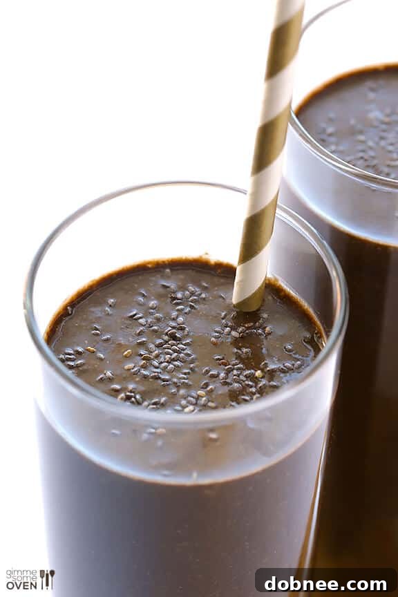 Hand holding a glass of a rich, creamy Chocolate Chia Smoothie