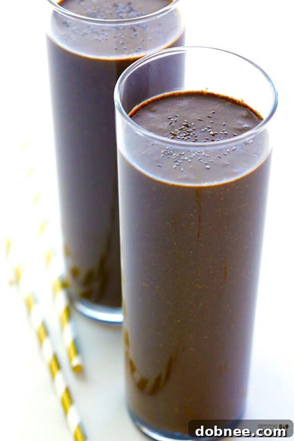Chocolate Chia Smoothie in a glass, with a straw, on a rustic surface