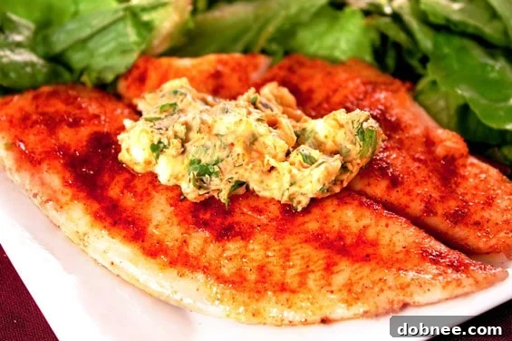 Perfectly pan-seared tilapia fillets topped with melting cilantro-lemon butter and fresh lemon wedges, ready to serve.