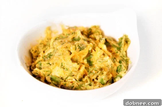 A close-up of a pan-seared tilapia fillet, golden brown and flaky, with a generous dollop of rich cilantro-lemon butter melting on top, garnished with a sprig of fresh cilantro.