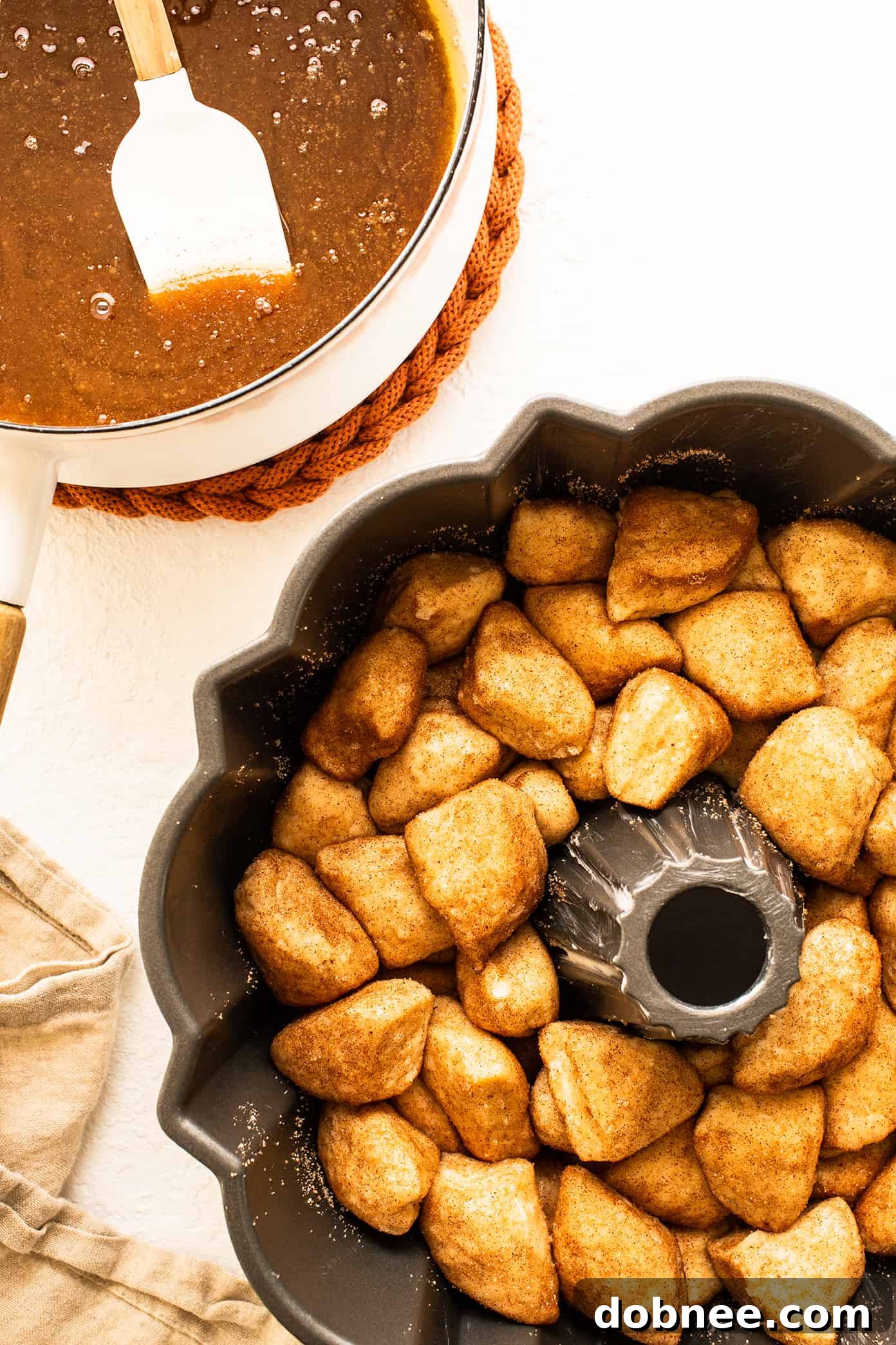 Close-up of baked monkey bread in a bundt pan, showing the golden-brown crust and gooey sauce
