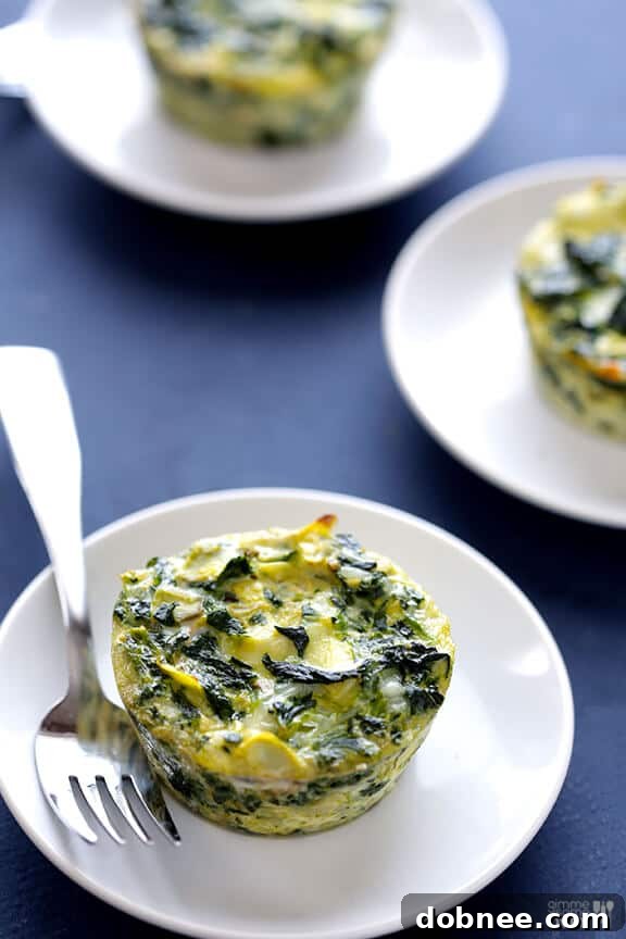 A close-up of a single Easy Spinach Artichoke Quiche Cup, ready to eat.