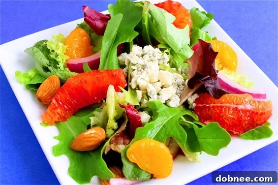 A vibrant and colorful orange salad with mandarin-cider vinaigrette, served in a bowl, perfect for brightening up any meal.