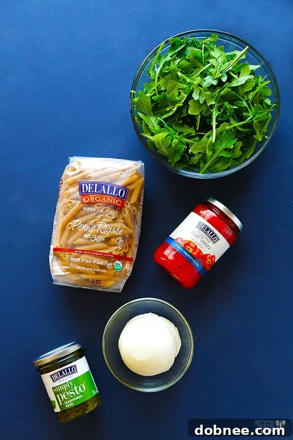 Simple 5-Ingredient Pasta Salad: A flavorful blend of whole wheat pasta, fresh arugula, mozzarella, roasted red peppers, and DeLallo basil pesto. | dobnee.com