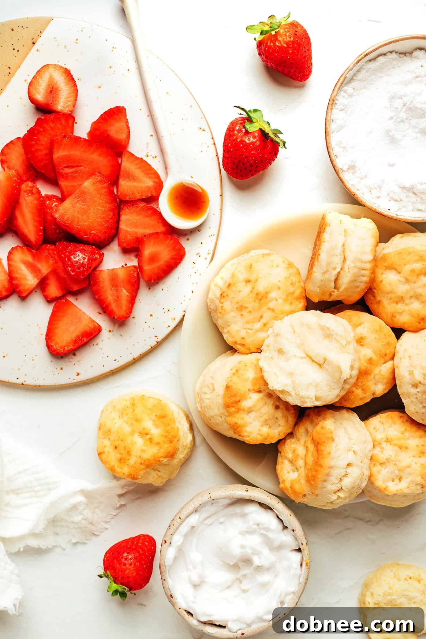 A bowl of thinly sliced fresh strawberries, glistening and vibrant, ready for assembling the shortcake.