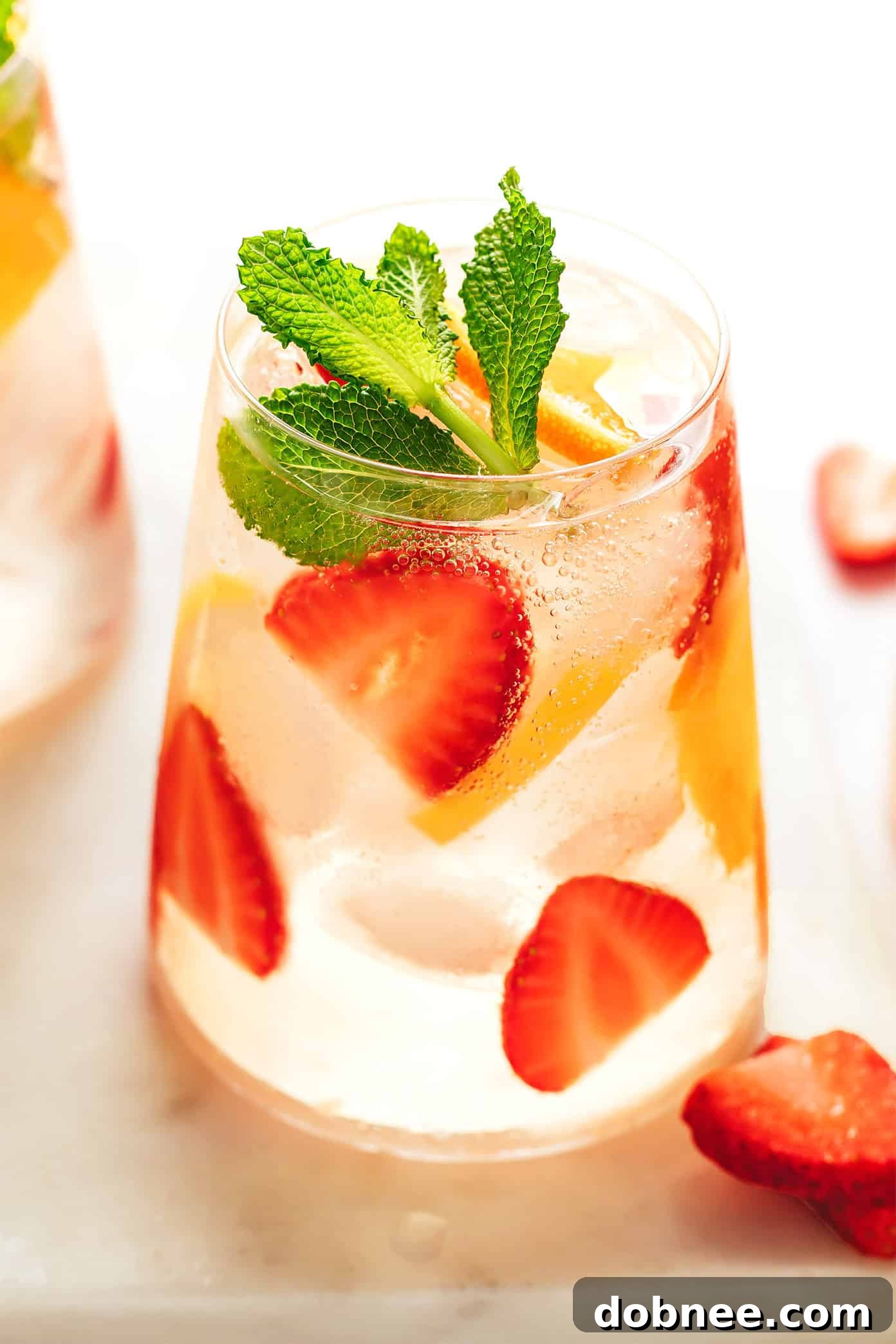 strawberry sangria pitcher with glasses and fresh fruit