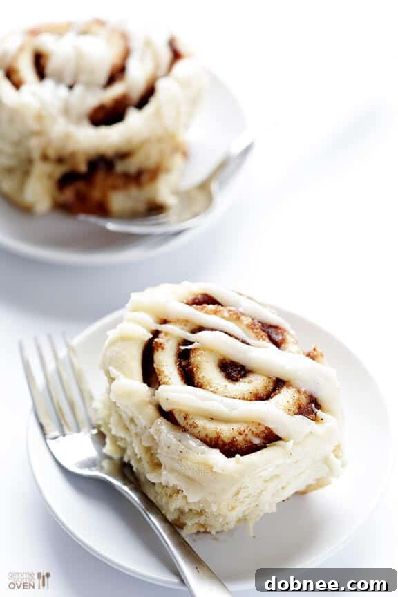 Enjoying a bite of a freshly frosted brown butter cinnamon roll.