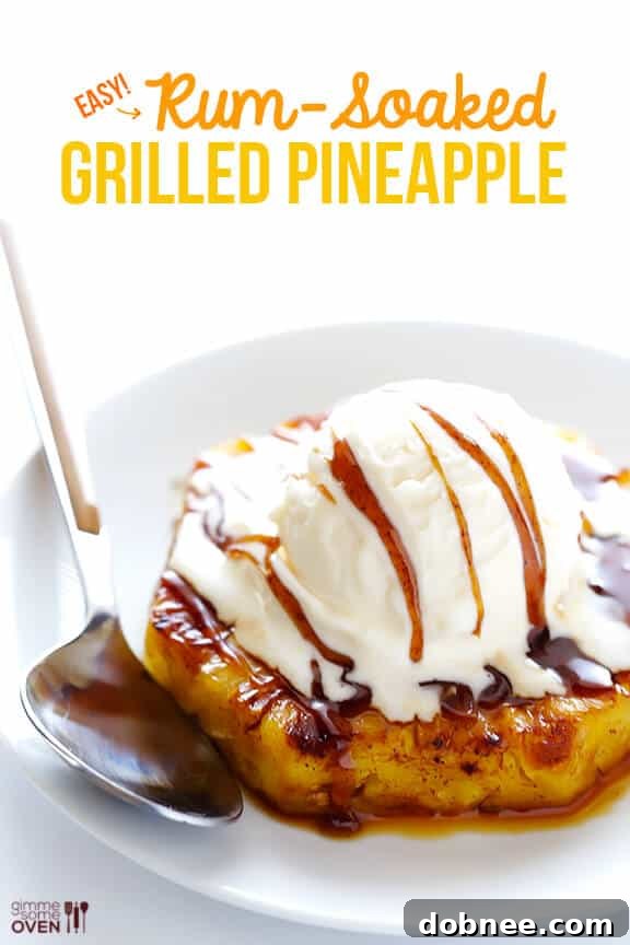 Easy Rum-Soaked Grilled Pineapple with a scoop of melting vanilla ice cream and a rich caramelized rum sauce, garnished with cinnamon.