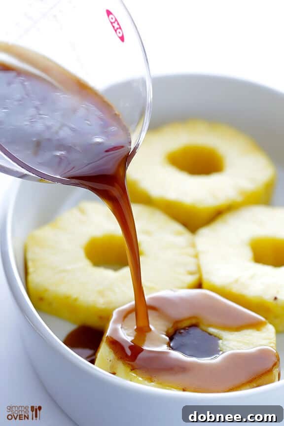 Fresh pineapple being prepared for the rum-soaking and grilling process, showing slices and the removed core.