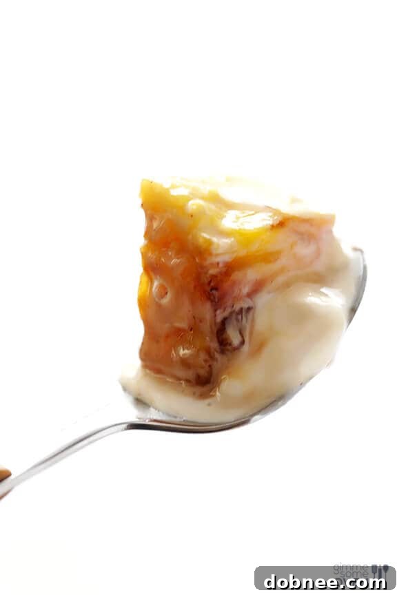 Final plated dessert of rum-soaked grilled pineapple with vanilla ice cream and sauce, ready to be enjoyed.