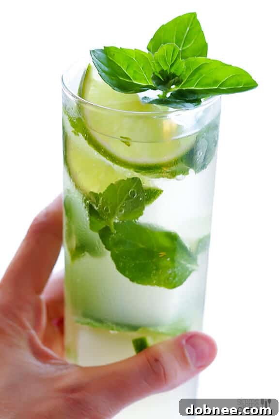Refreshing Ginger Beer Mojito in a glass with mint and lime slices, a perfect summer drink.