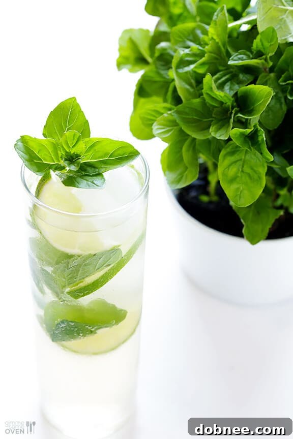 A beautifully garnished Ginger Beer Mojito with lime and mint on a wooden surface.