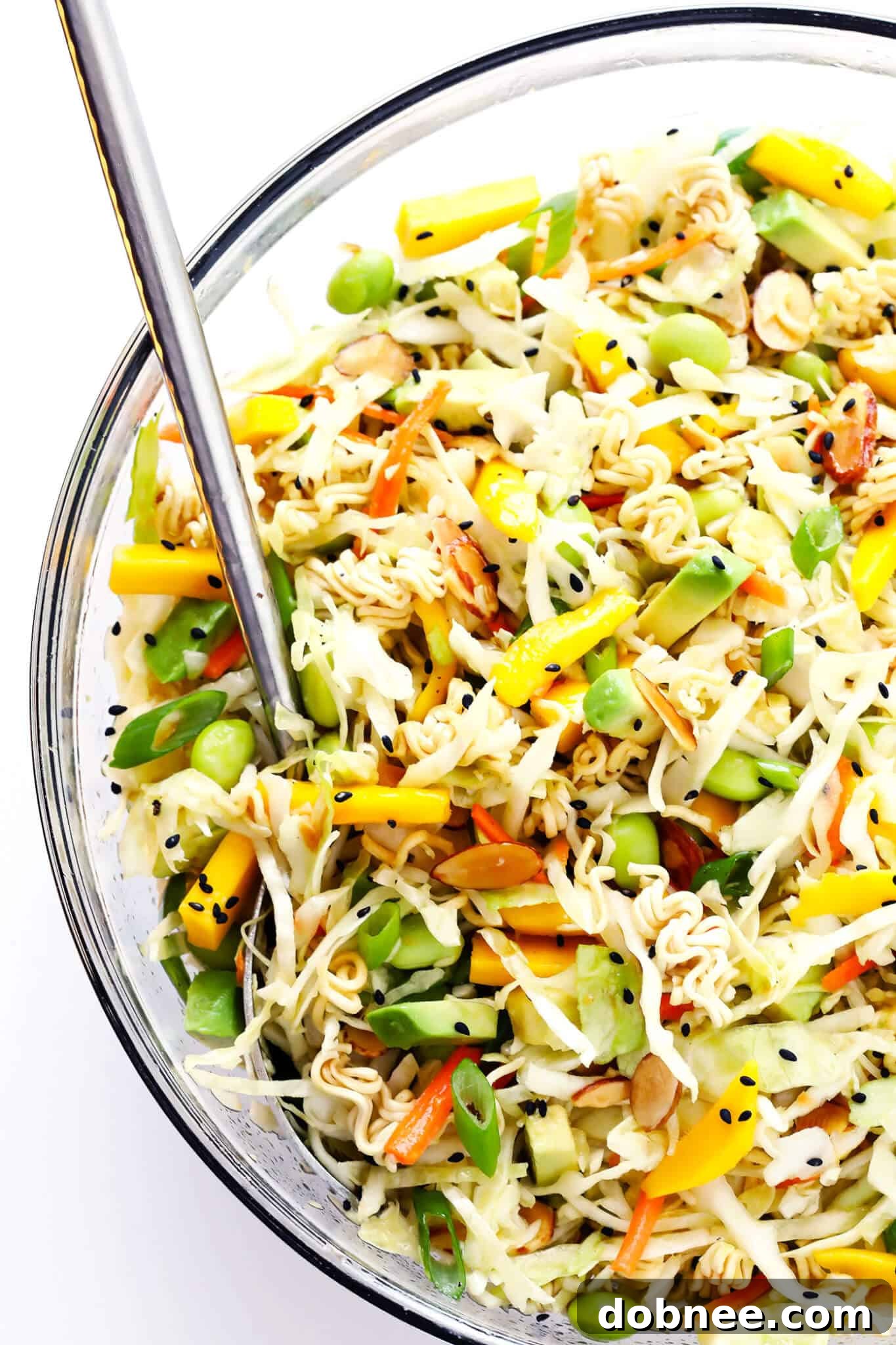 This Crunchy Asian Ramen Noodle Salad is easy to make, tossed with fresh mango, avocado, edamame, cole slaw, almonds, and a sesame honey vinaigrette...and SO delicious! Perfect for potlucks, picnics, or as a simple salad or side dish. | gimmesomeoven.com