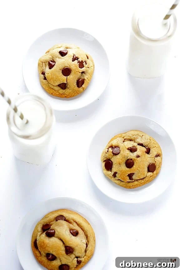 A batch of golden-brown coconut oil chocolate chip cookies cooling on a wire rack