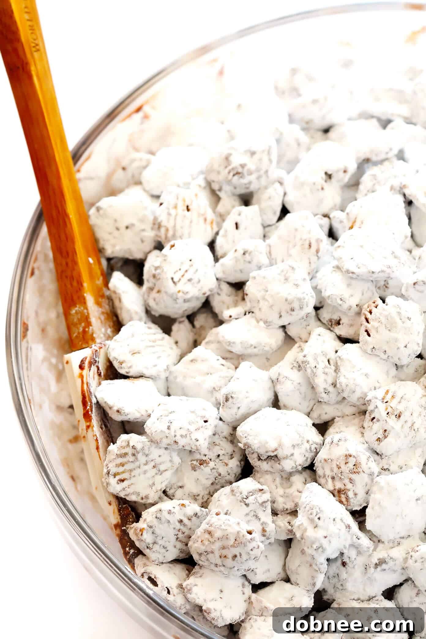 Chocolate-coated cereal being shaken with powdered sugar in a large ziplock bag.