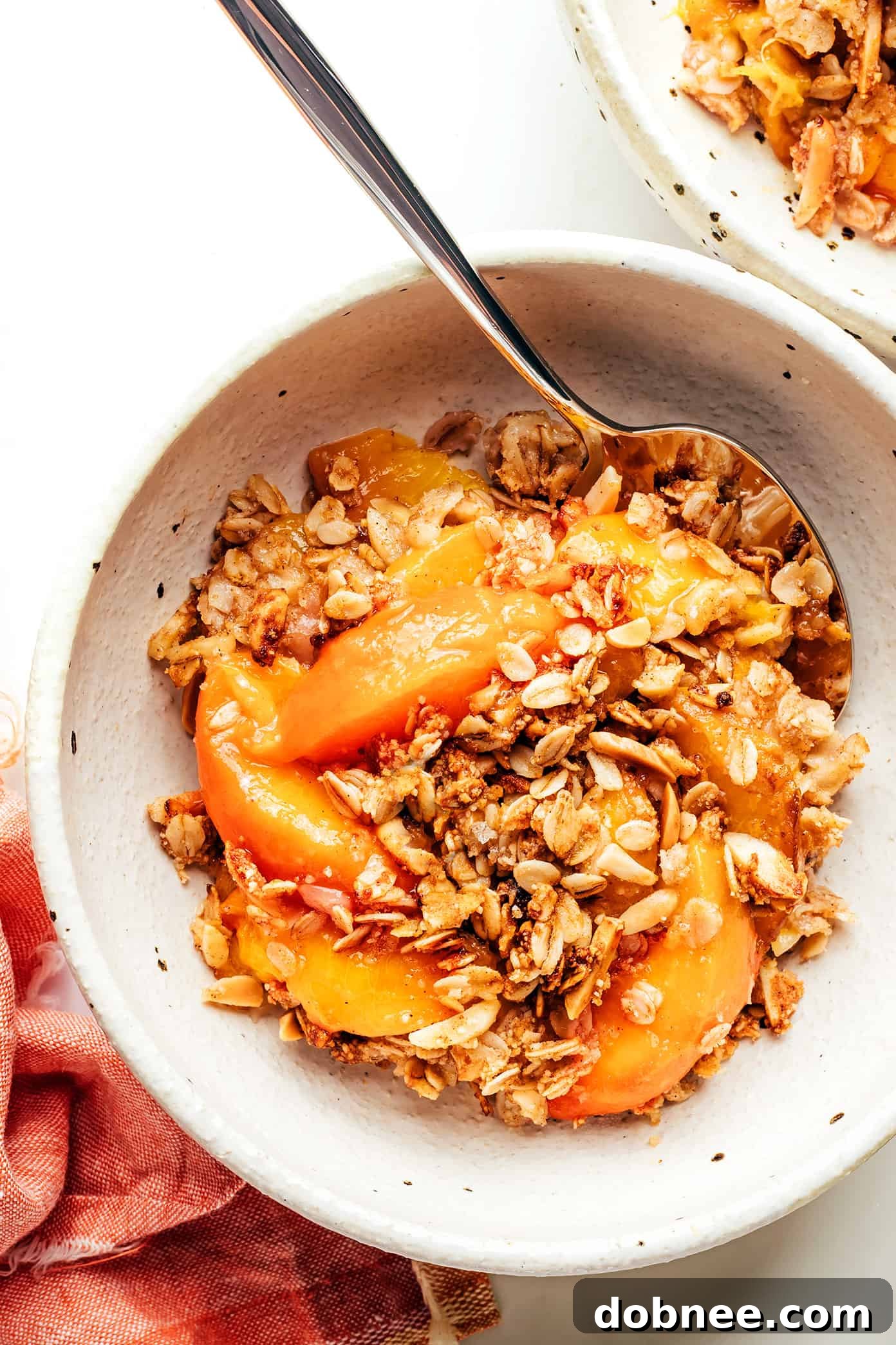 Ginger Peach Crisp, a warm ginger-vanilla peach filling with a crispy almond oat topping, perfect for summer dessert.