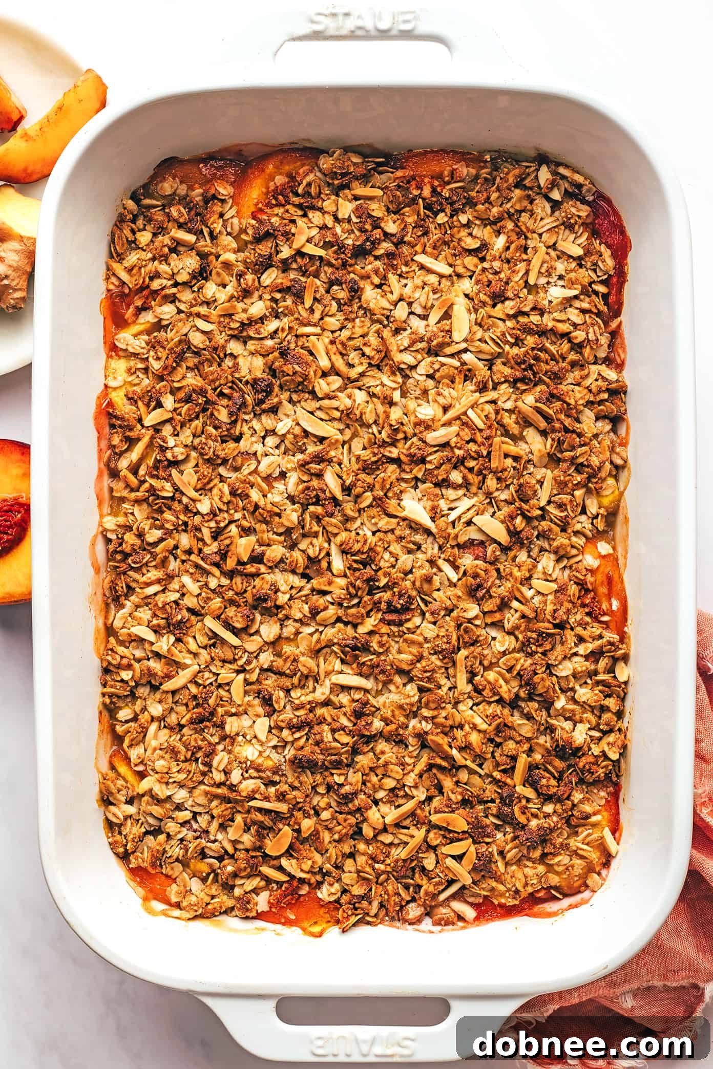 Baked Ginger Peach Crisp in a baking pan, golden brown and bubbly.