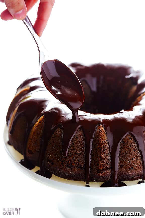 Greek Yogurt Chocolate Cake cooling on a wire rack with chocolate glaze drizzle