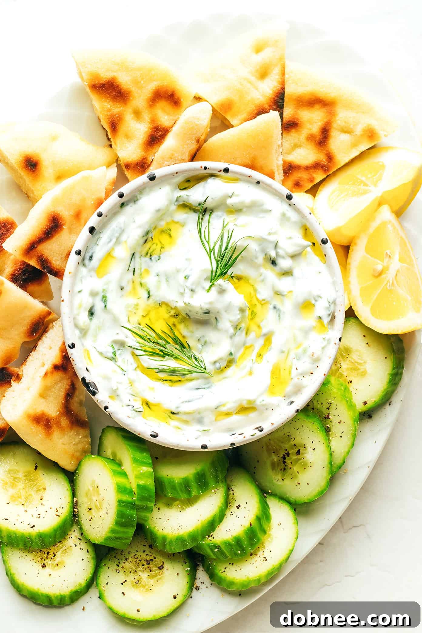 Refreshing Cucumber Yogurt Dip 2 Freshly prepared Tzatziki dip with a vibrant green hue, garnished with fresh dill and a drizzle of olive oil, ready to be served.