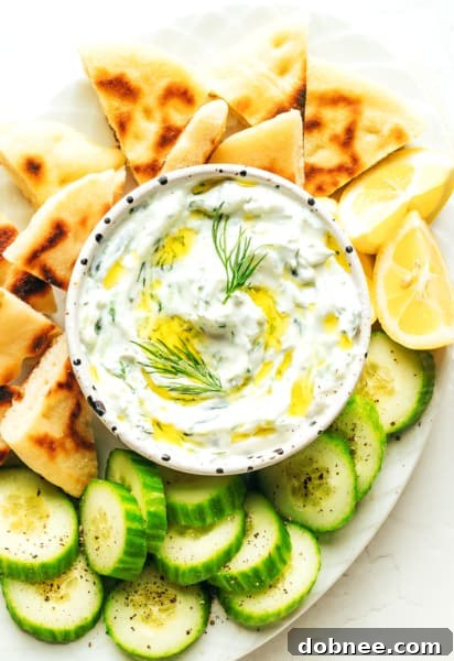 A bowl of freshly made Tzatziki, garnished with a sprig of fresh dill, showcasing its creamy texture and vibrant appearance.