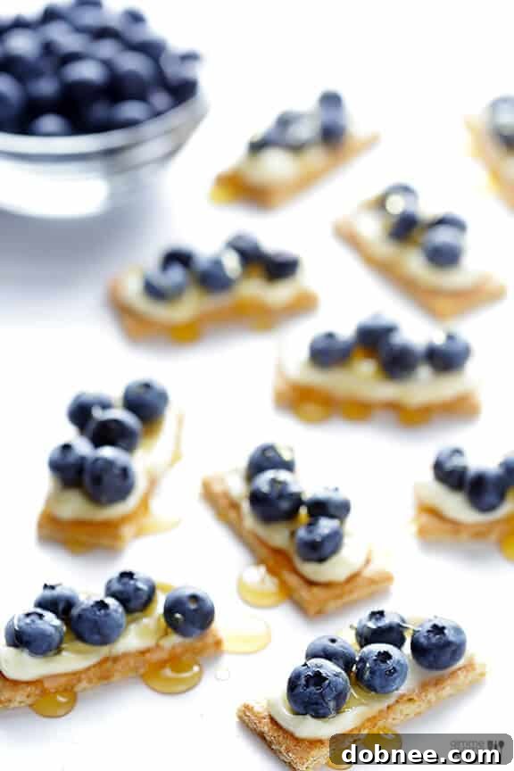 A hand reaching for an easy blueberry cheesecake bite to take a bite.