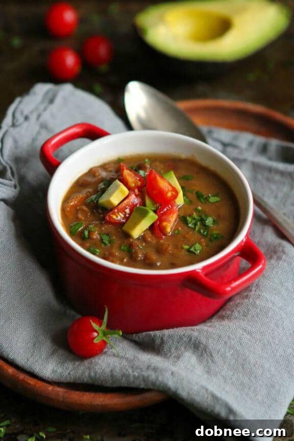 Spicy Slow Cooker Chipotle Lentil Soup with fresh avocado slices