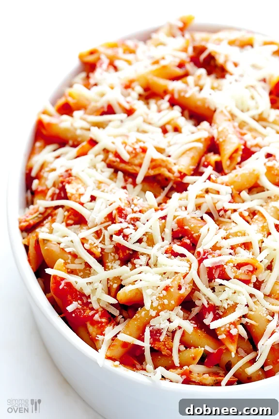 A serving of Chicken Parmesan Baked Ziti on a plate with fresh basil.