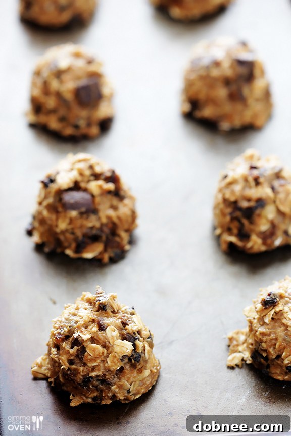 Scooping Breakfast Cookies Dropping spoonfuls of breakfast cookie dough onto a baking sheet.