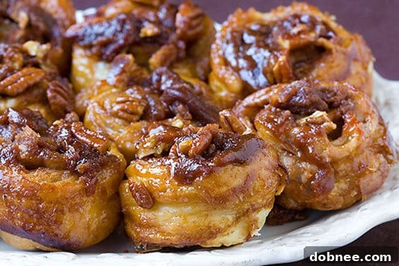 Golden-brown sticky buns fresh out of the oven, glistening with caramel and pecans, ready to be enjoyed.