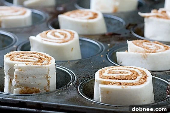 A closer view of the baked sticky buns, showcasing their golden crust, sticky caramel bottom, and pecan topping, arranged on parchment paper.