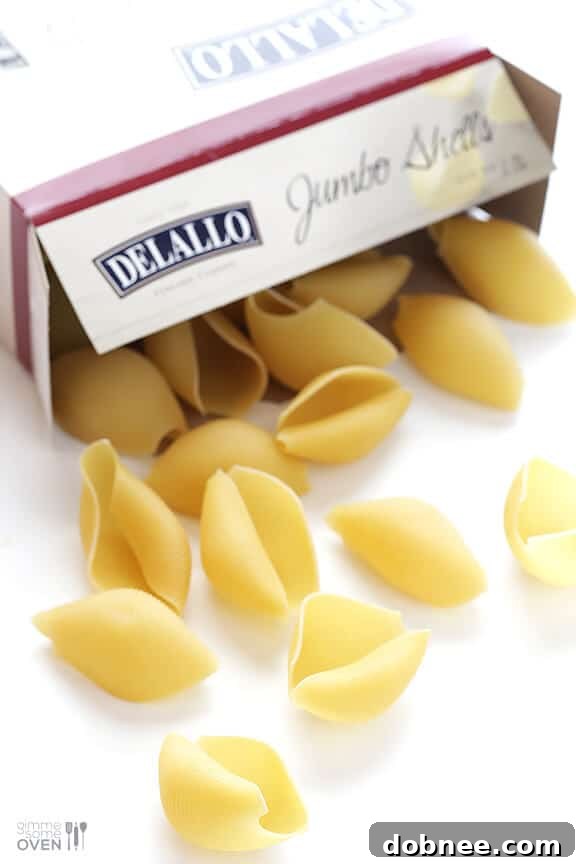 Close-up of baked butternut squash alfredo stuffed shells, garnished with fresh herbs.