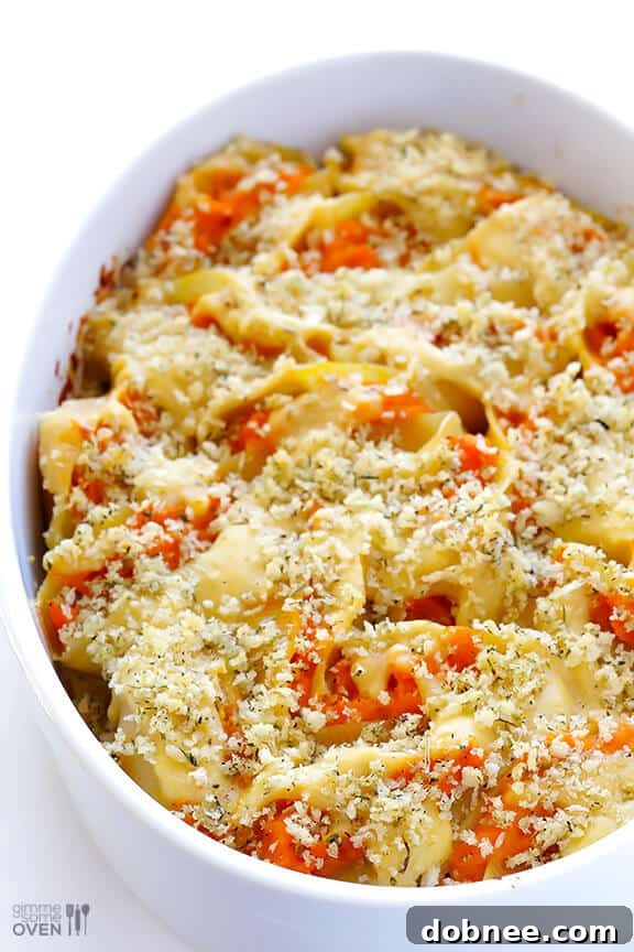 Mashing roasted butternut squash with alfredo sauce to create a smooth, creamy filling.