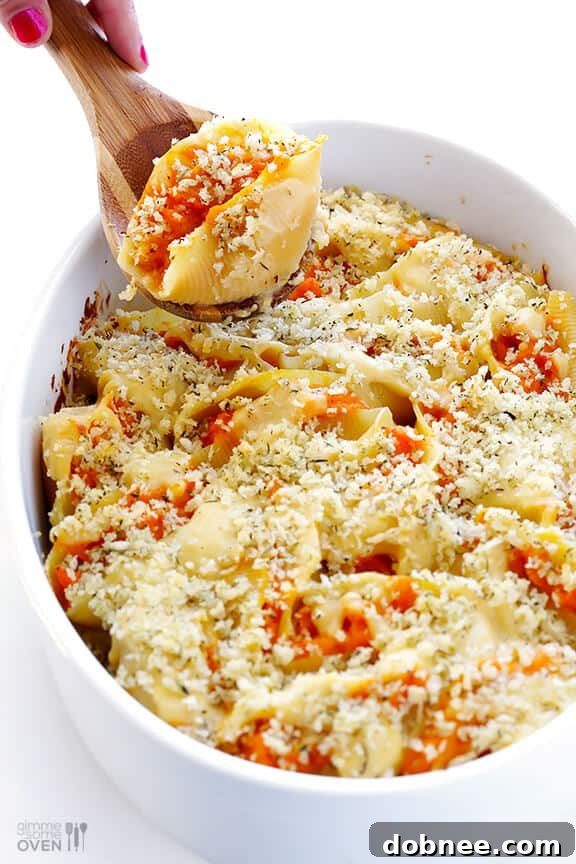 Butternut squash filling being neatly stuffed into jumbo pasta shells.