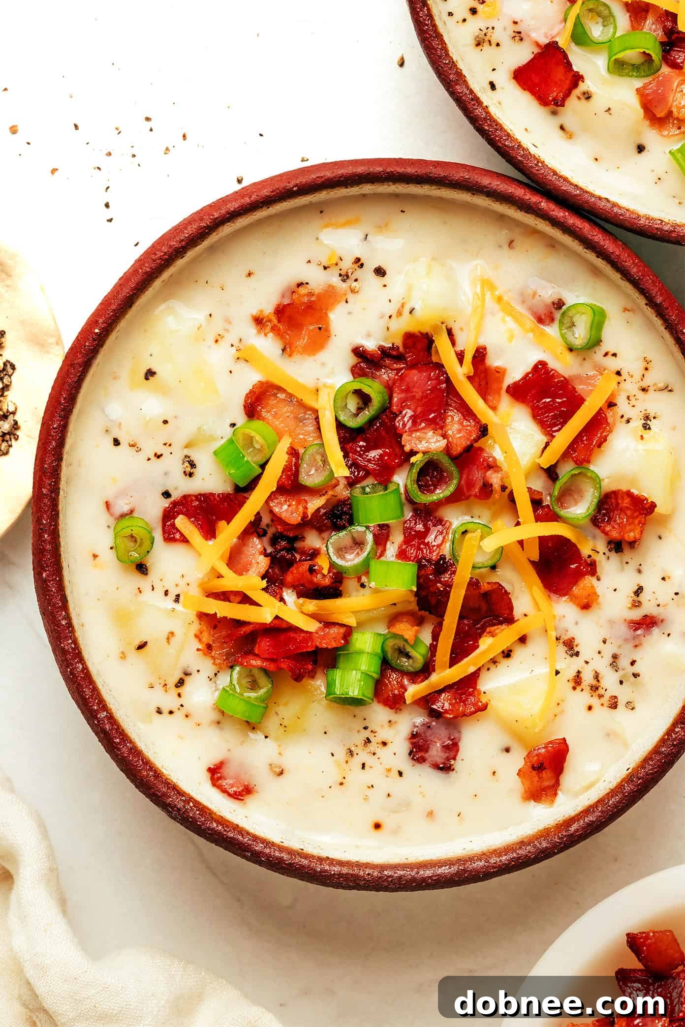 A beautifully presented bowl of creamy potato soup, garnished and ready to serve.