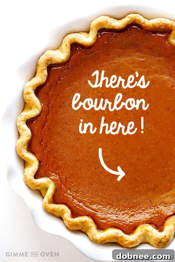 A slice of Bourbon Pumpkin Pie with whipped cream, ready to be enjoyed. Discover the perfect blend of classic pumpkin flavor and a hint of bourbon in this easy recipe.