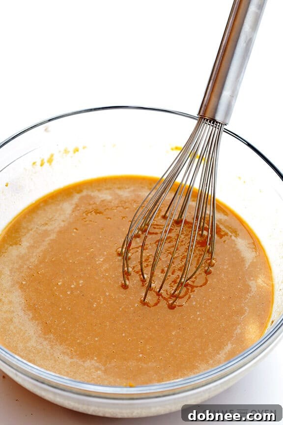 Preparing the pumpkin pie filling: a bowl of vibrant orange pumpkin puree, ready for the bourbon and spices.