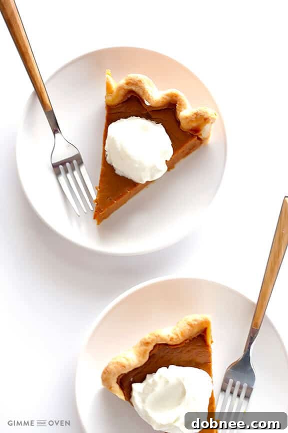 A beautifully presented Bourbon Pumpkin Pie, showcasing its golden crust and smooth, spiced filling, a perfect centerpiece for any dessert table.