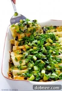 Breakfast Enchiladas with sausage, eggs, cheese, and avocado in a green enchilada sauce.