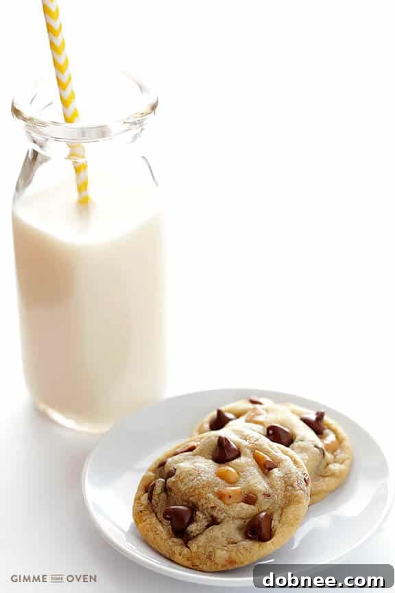 A stack of warm Toffee Chocolate Chip Cookies on a cooling rack, showcasing their golden edges and soft centers.