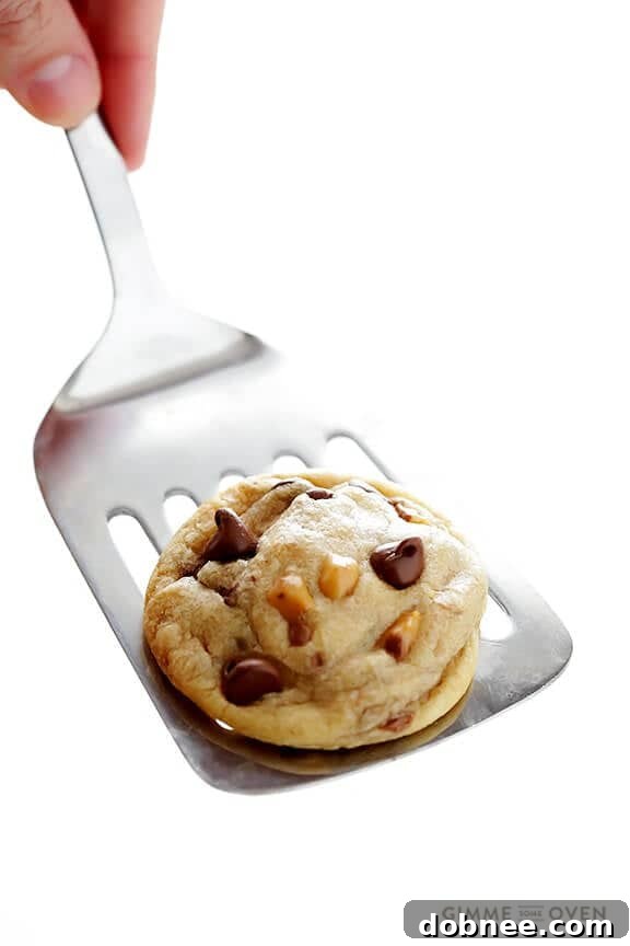 Freshly baked Toffee Chocolate Chip Cookies cooling on a wire rack, steam gently rising.