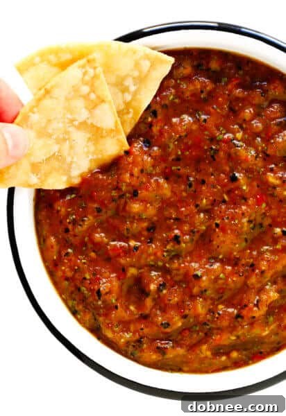 Roasted Tomato Salsa in a bowl with tortilla chips, cilantro, and limes