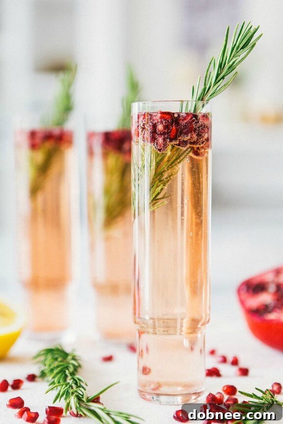 Beautiful Pomegranate Rosemary Spritzer with fresh rosemary sprigs