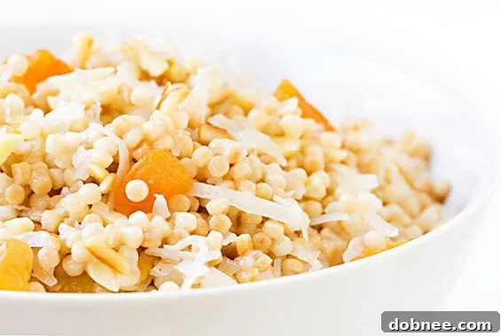 Healthy breakfast bowl of Israeli couscous with apricots, almonds, and coconut, served in a white bowl, ready to be enjoyed