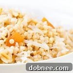 Prepared Breakfast Israeli Couscous in a small bowl, garnished with apricots, almonds, and coconut flakes