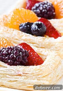 Stacked Berry and Ricotta Danishes, garnished with berries and powdered sugar