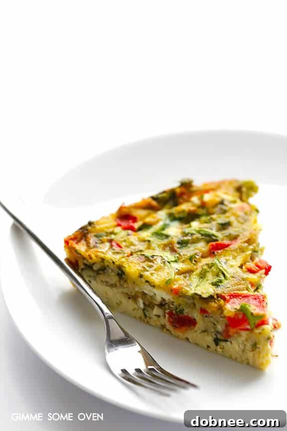 A slice of the Baked Frittata on a plate, showing the layers of peppers, arugula, and pesto.
