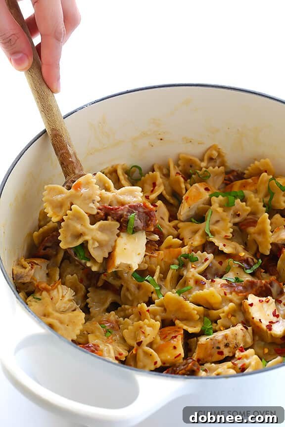 Creamy Pasta with Chicken & Sun-Dried Tomatoes tossed together, ready to serve