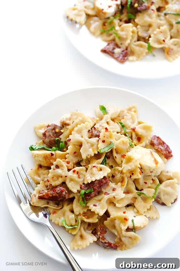 A full serving of Creamy Pasta with Chicken & Sun-Dried Tomatoes, garnished with fresh basil